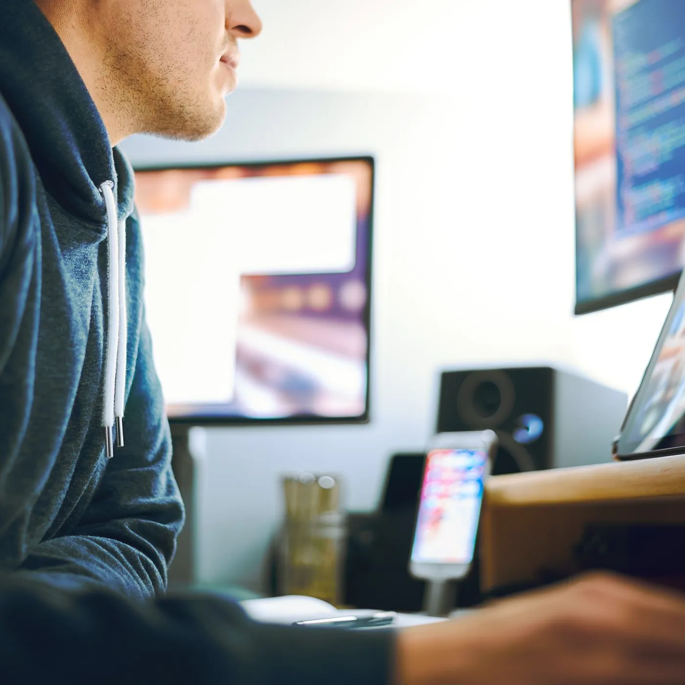 An engineer working at a desk with several screens